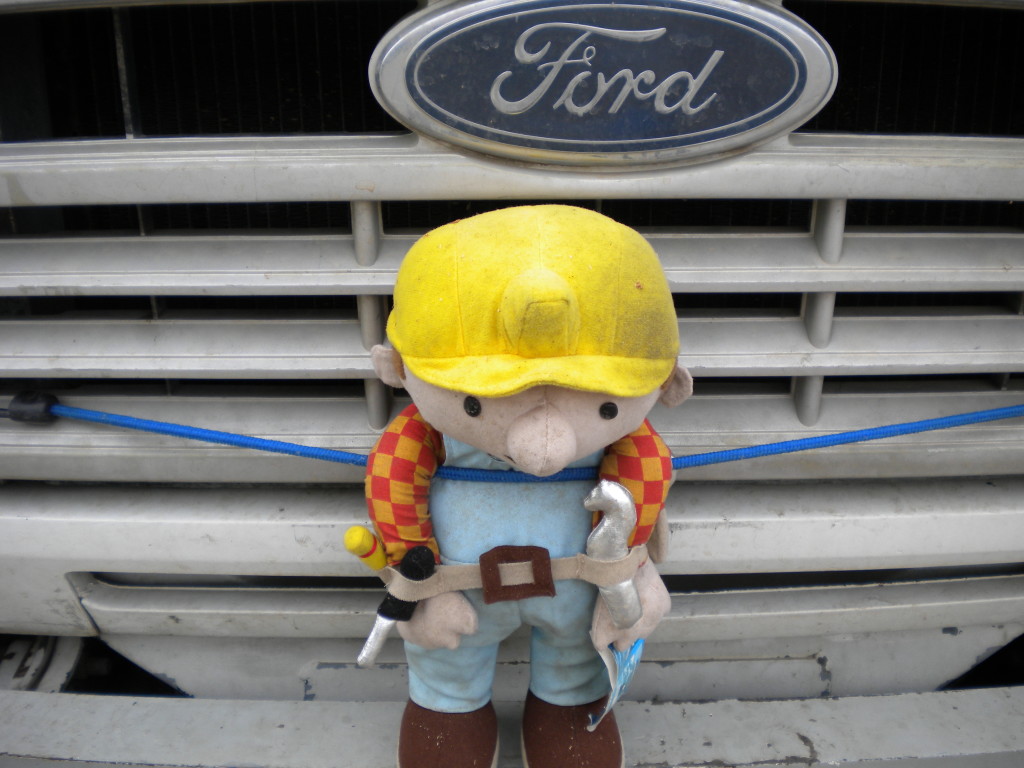 workman riding on the front of the Ford